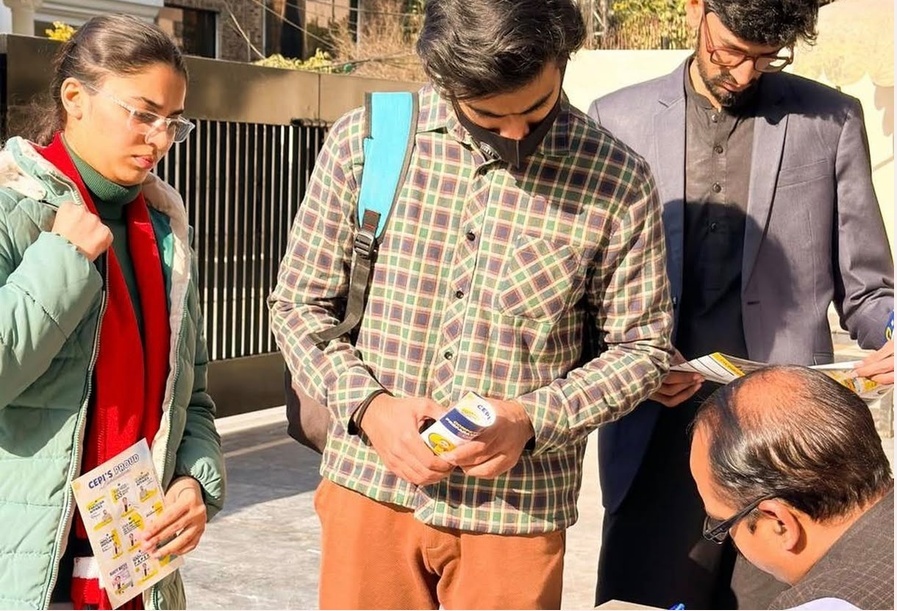 CEPI street activation: students reading flyers outside campus